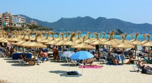 Buntes Strandleben vor attraktiver Bergkulisse – typisch Mallorca.